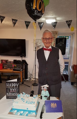 Dennis Busby with his balloons and cake on his 100th birthday